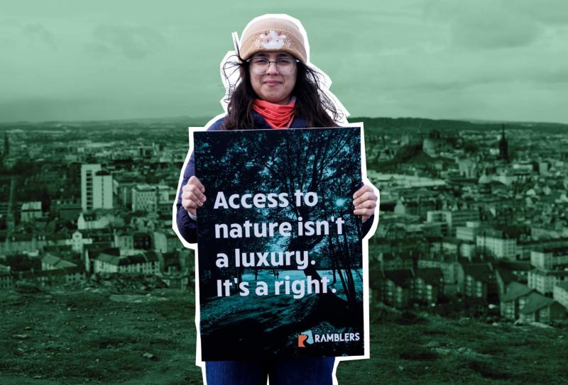 A young woman stands with a sign saying Access Denied